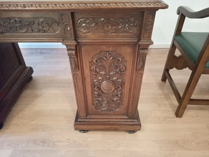 Ornato piedistallo in legno intagliato con motivi floreali e volute nel set di scrivania studio stile eclettico in noce pelle verde