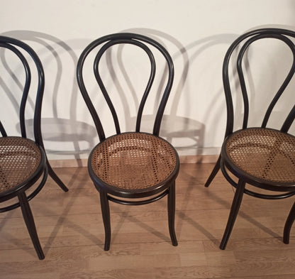 Tre sedie nere in faggio curvato con sedili in vimini nello stile thonet italia set, disposte in fila